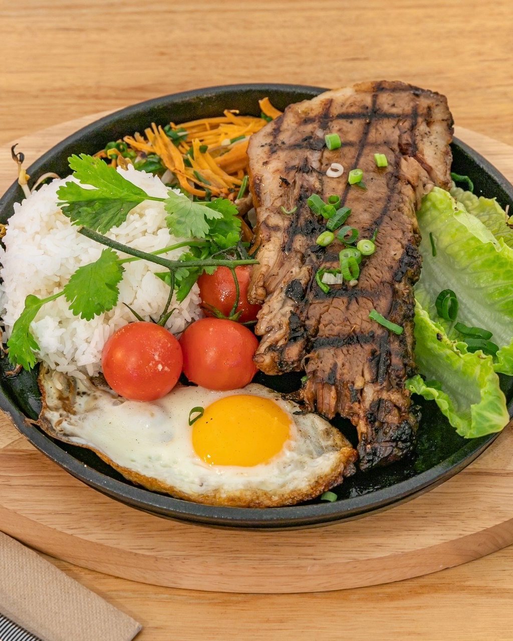 Sizzling steak plate with egg, rice and bean sprouts